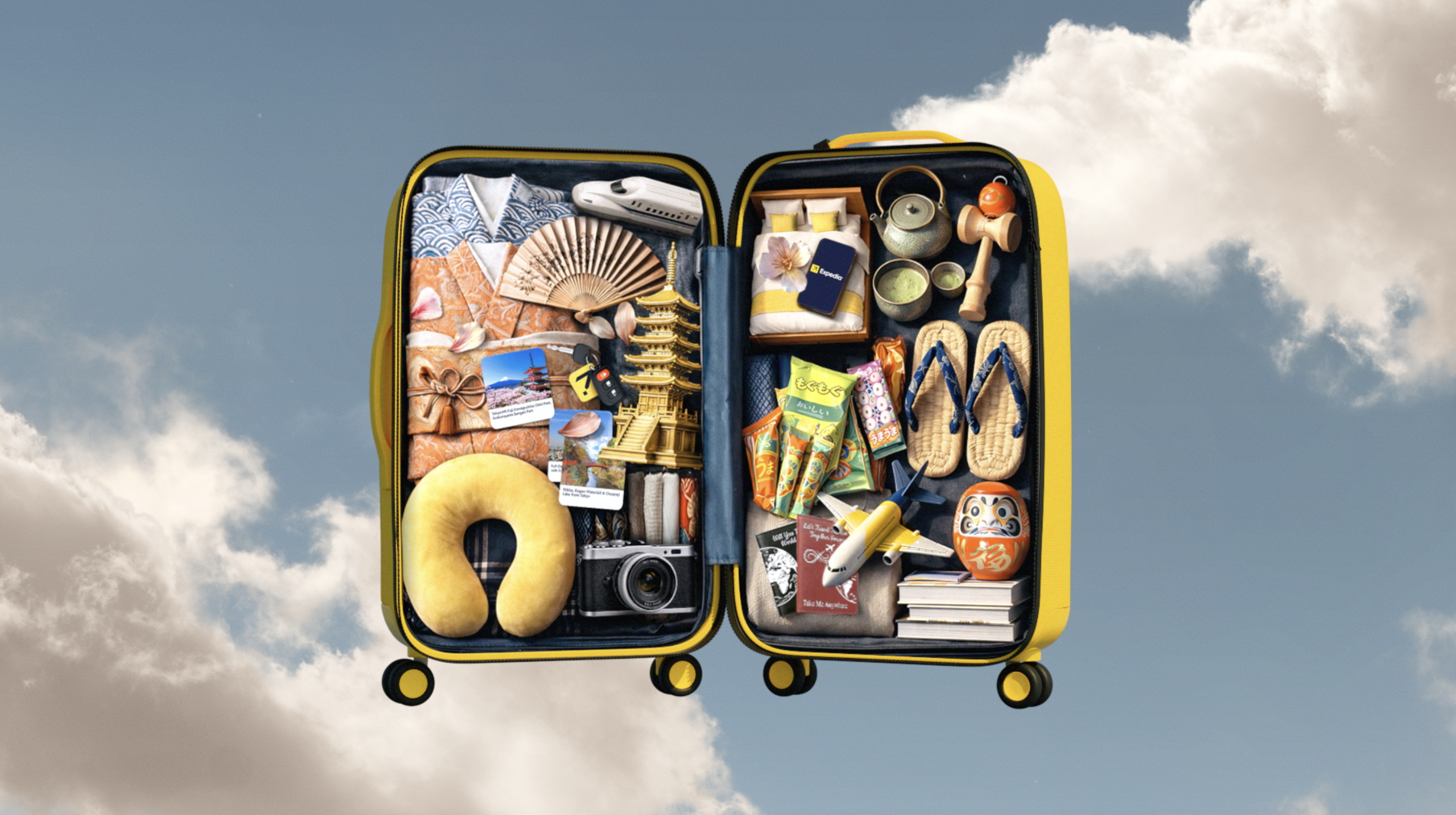 Open yellow suitcase against a cloudy sky, packed with various travel items. Includes Japanese souvenirs, snacks, camera, and travel essentials.
